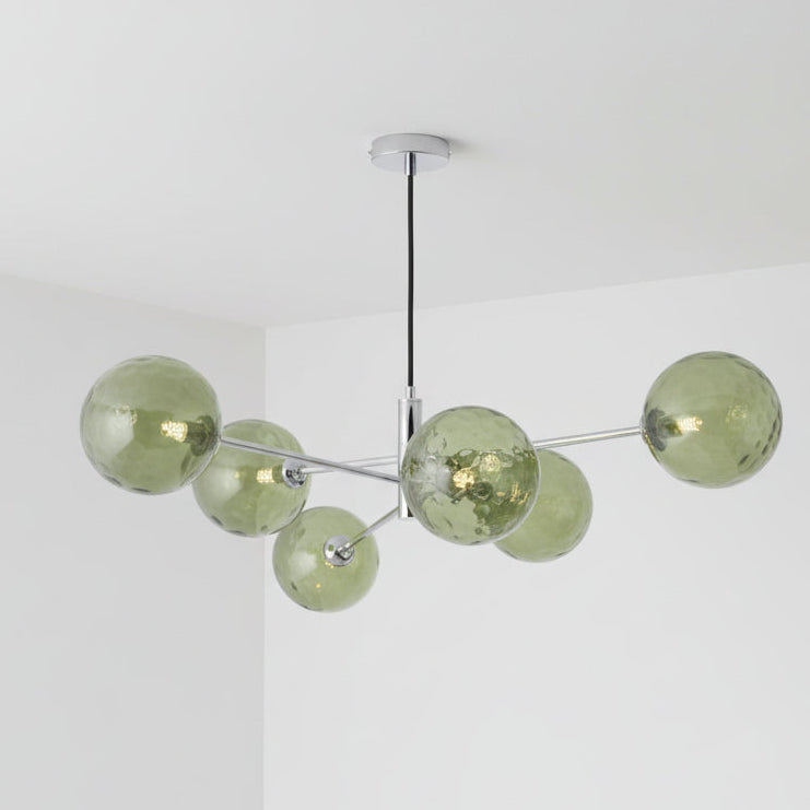 Modern chandelier with six green textured glass globes on chrome arms, suspended from a black cord.