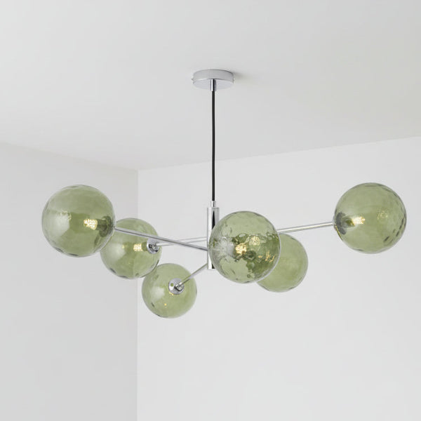 Modern chandelier with six green textured glass globes on chrome arms, suspended from a black cord.