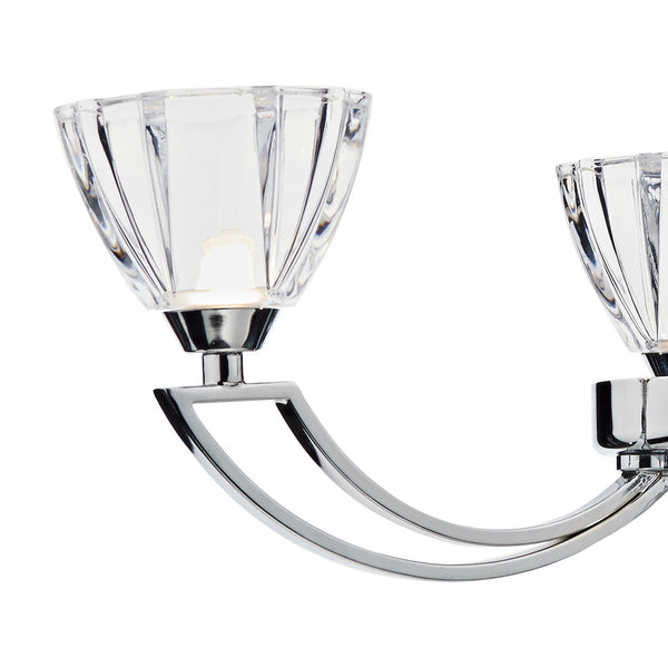 Close-up of a modern chrome light fixture with two faceted clear glass shades.