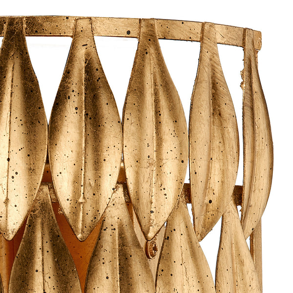 Close-up of a gold-colored decorative object with a leaf-like pattern and distressed finish.