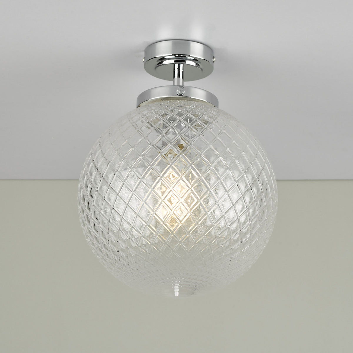 Clear glass globe ceiling light with a diamond pattern and chrome base.