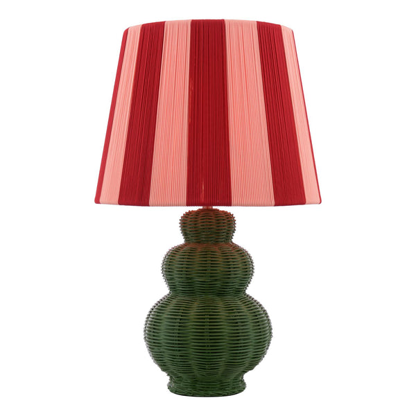 Table lamp with a green woven rattan base and a red and pink striped fabric shade