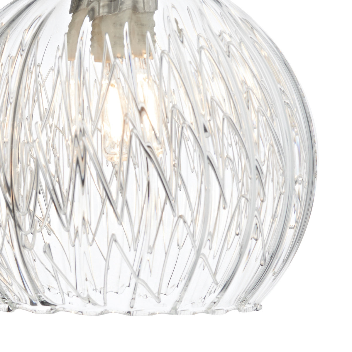 Close-up of a clear glass pendant light with a textured, wavy pattern and a glowing bulb inside.