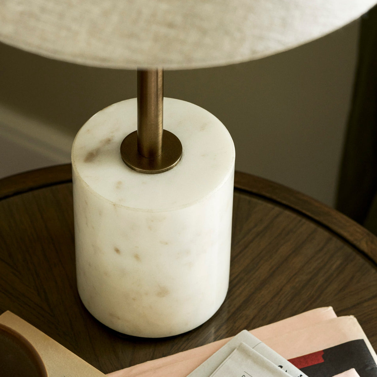 Close up of the Winsley brass and marble table lamp base on a wooden table with books