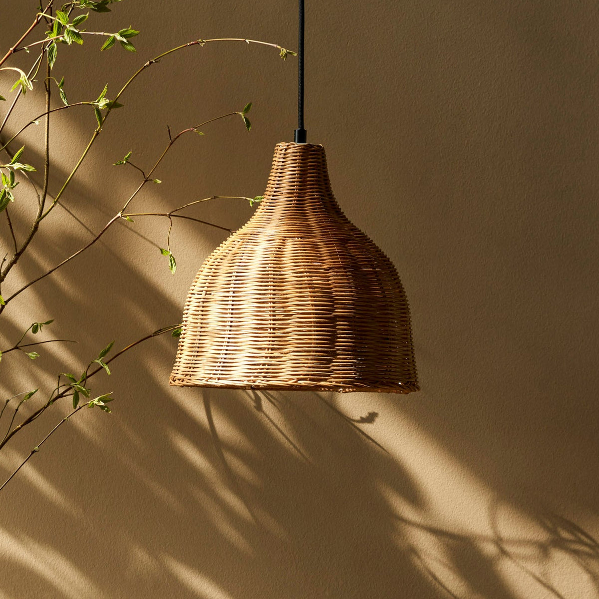 Mouldon Small Pendant in Rattan by Garden Trading Lighting suspended in a room with natural light