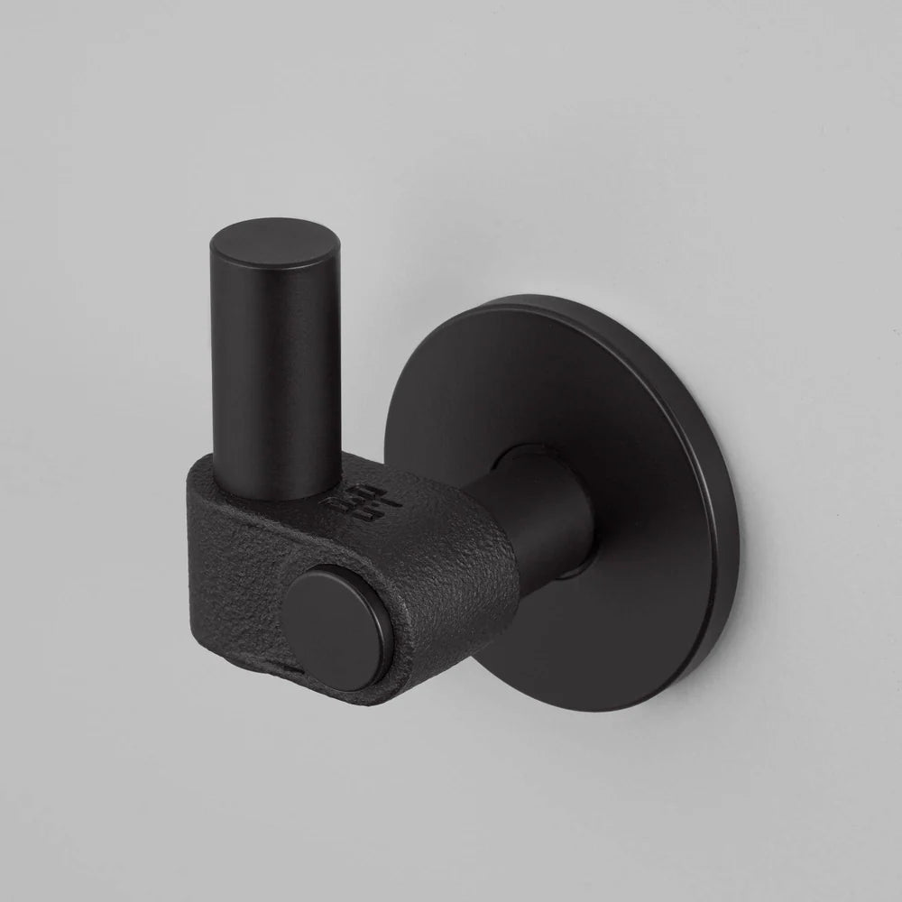 Black metal coat hook with a cylindrical top and a textured base