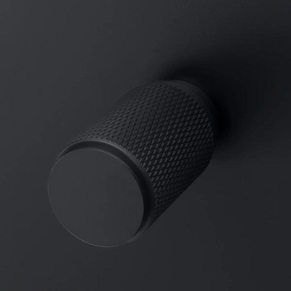 Black knurled knob on a black surface