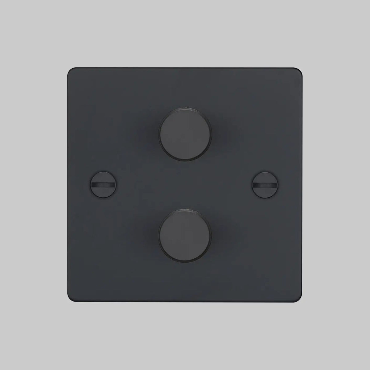 Black double dimmer switch with two circular knobs and two visible screws on a light grey background