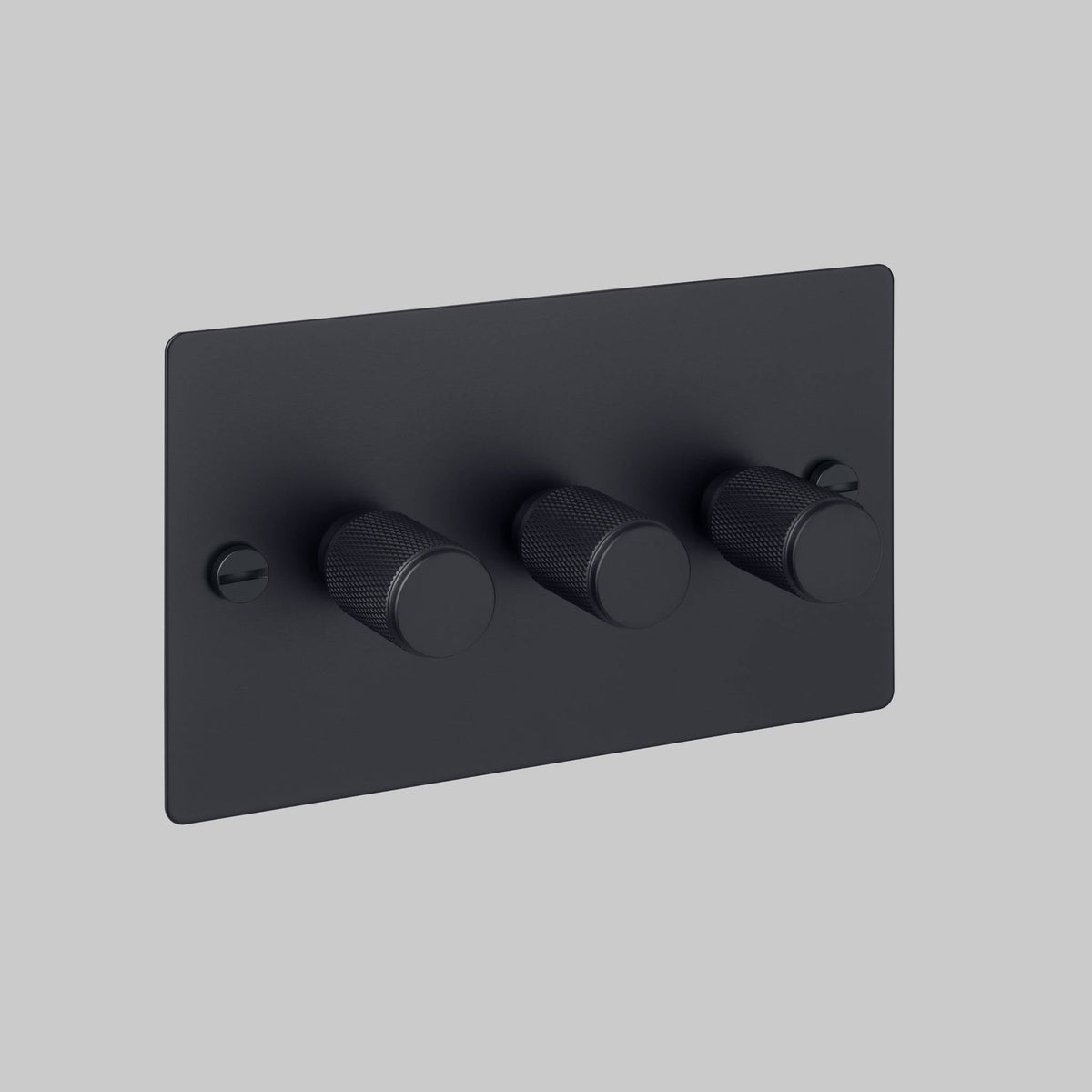 Three matte black dimmers with knurled edges on a rectangular matte black faceplate