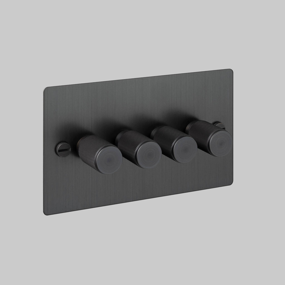 Four black knurled dimmer switches on a rectangular black faceplate with a visible screw on the left