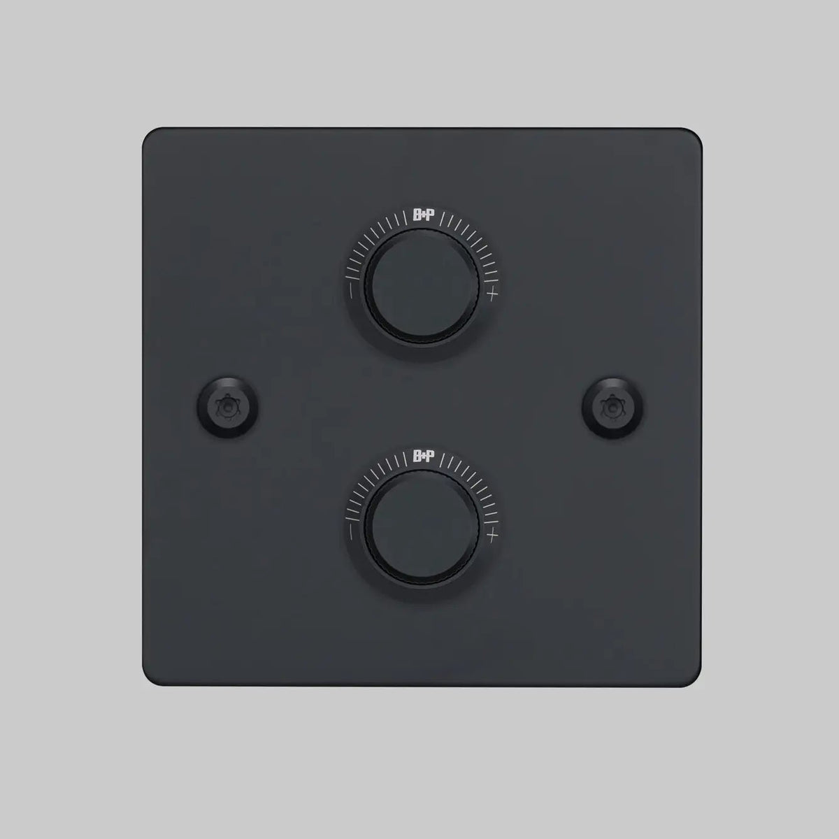 Two black circular dimmer switches on a matte black square plate