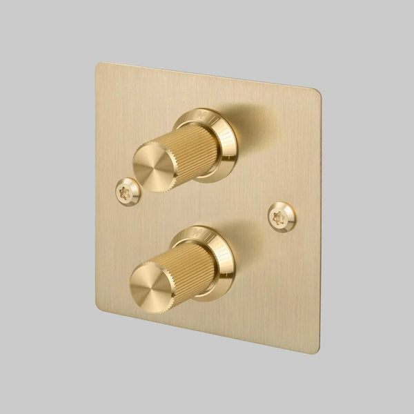 Brushed brass dimmer switch with two knurled rotary knobs and visible screws