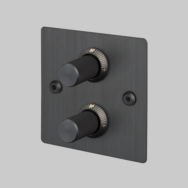 Black metal dimmer switch with two ribbed knobs and gold markings