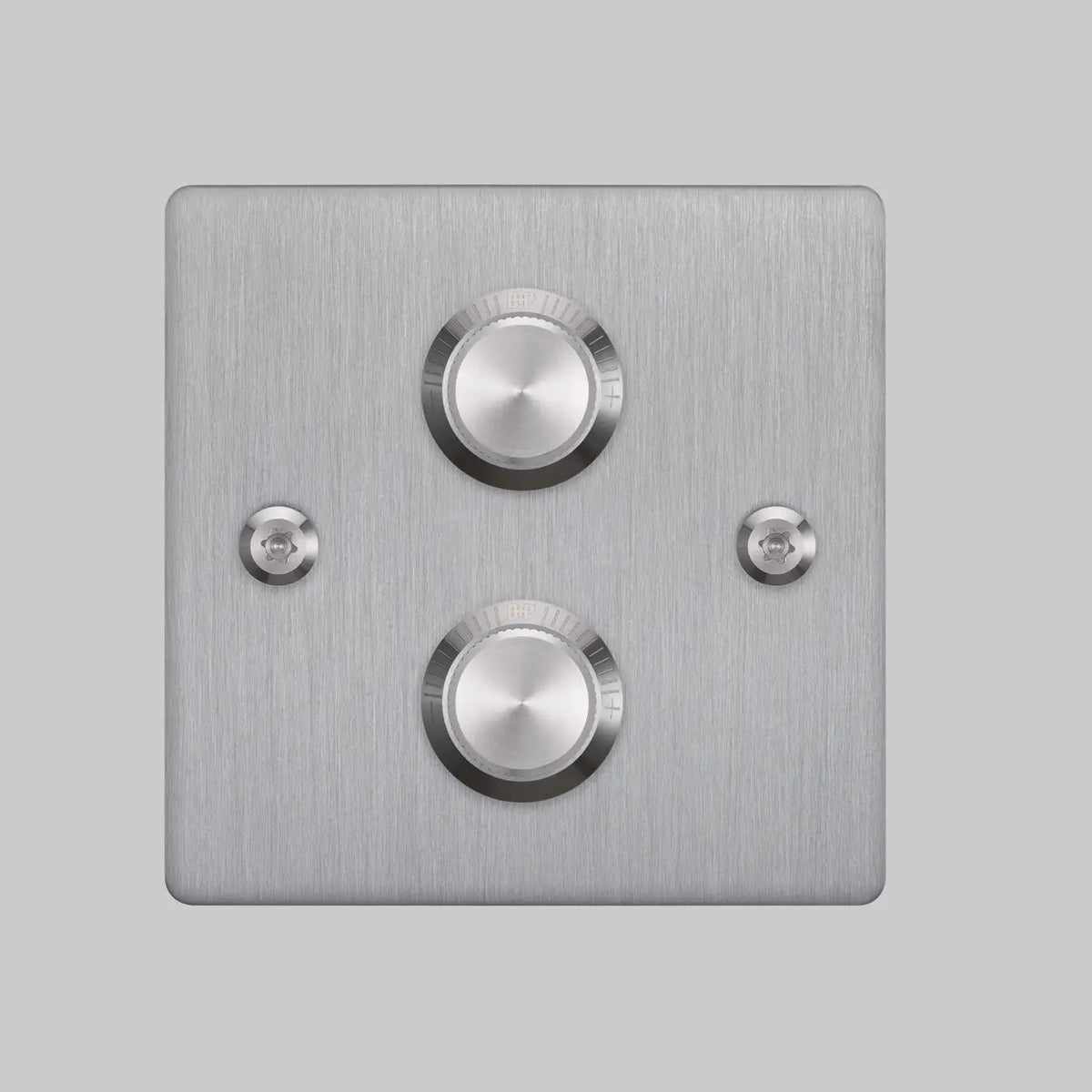 Brushed metal wall plate with two round, silver dimmer switches and two visible screws