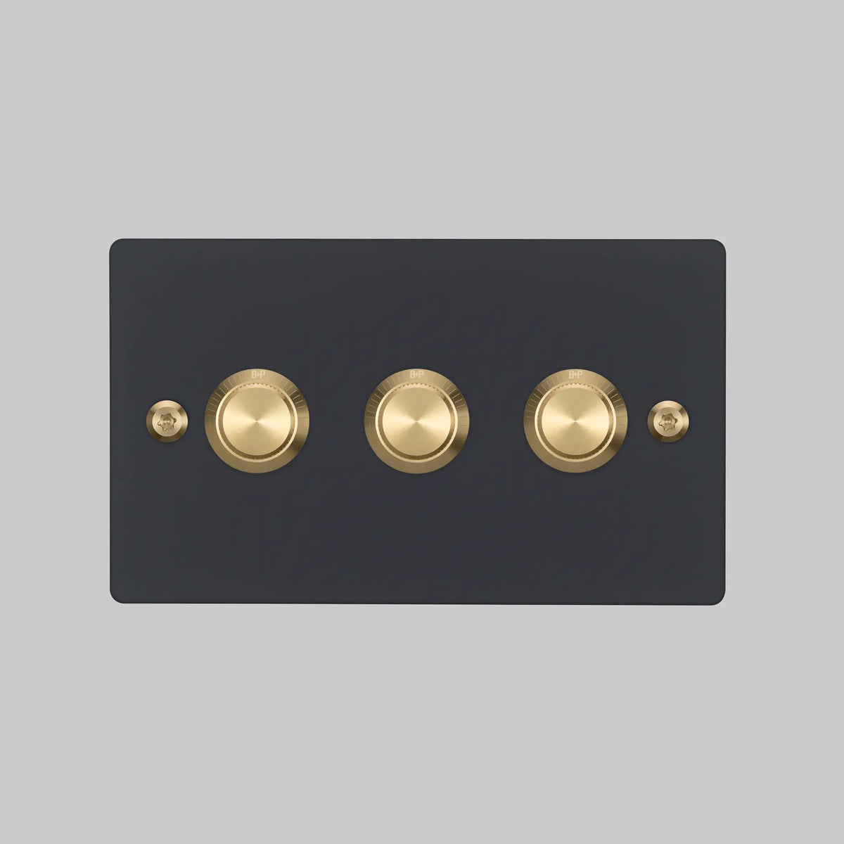 Buster and Punch three gang two way dimmer light switch in black with brass linear knurled knobs