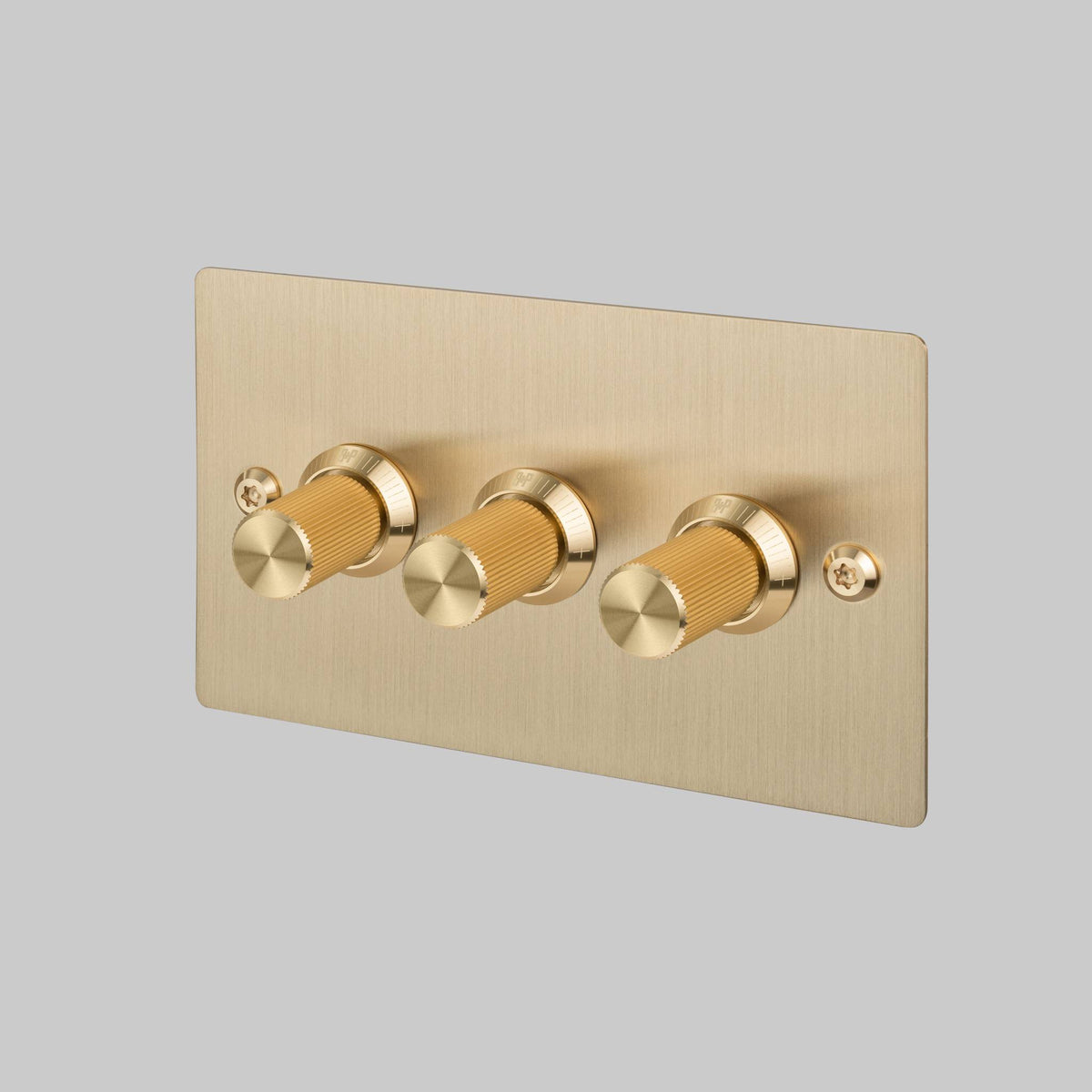 Brushed brass triple dimmer switch with three ridged cylindrical knobs