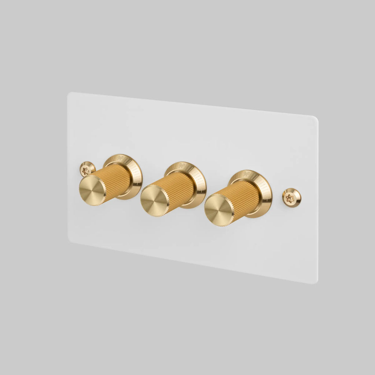 Buster and Punch three gang dimmer switch with white plate and brass linear knurled knobs