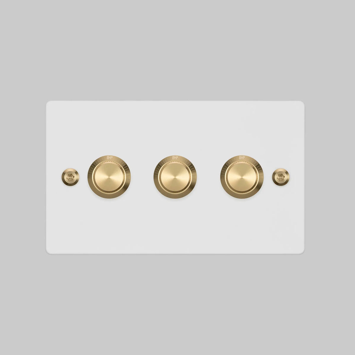 Buster and Punch three gang two way dimmer light switch in white with brass linear knurled knobs