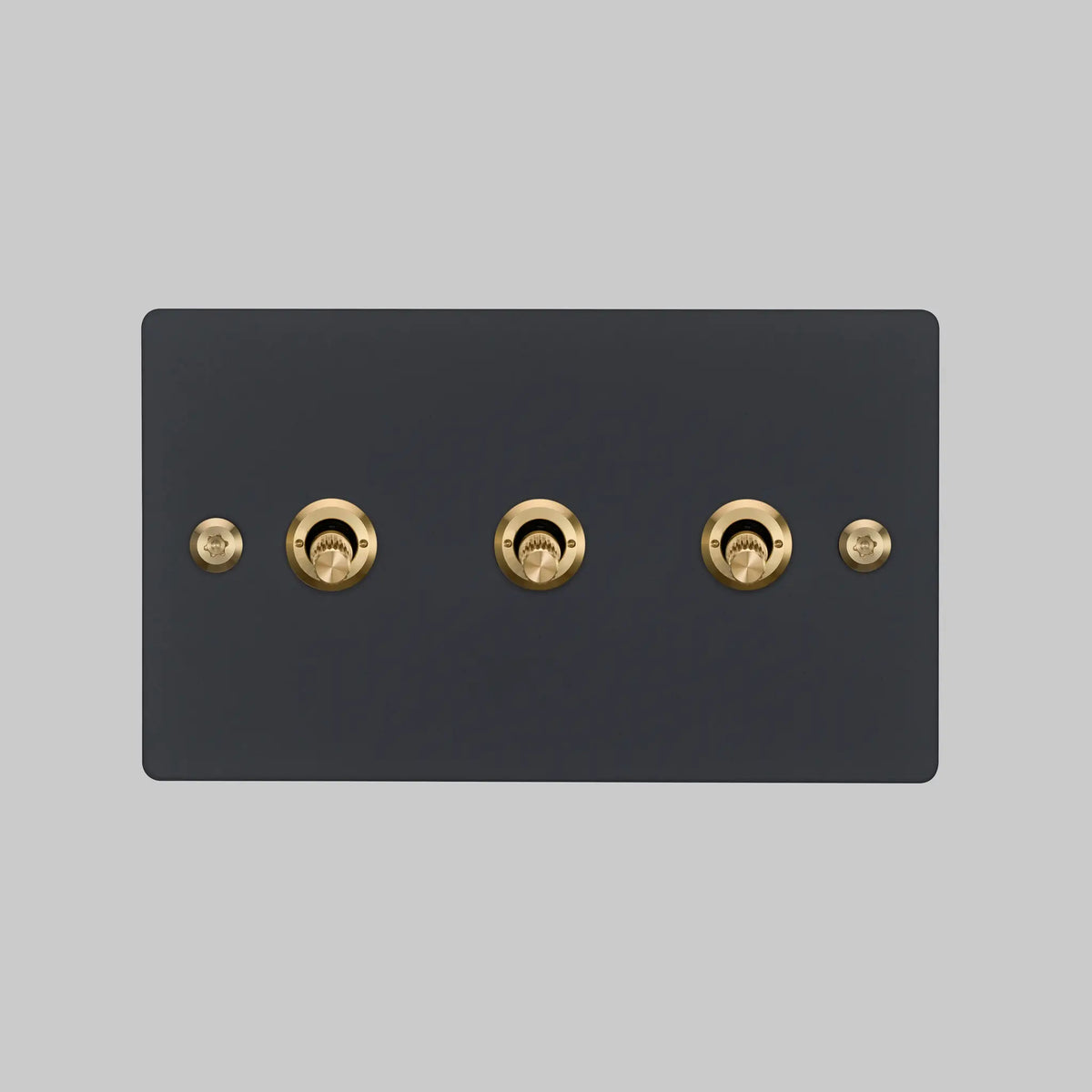 Buster and Punch three gang two way light switch in black with brass linear knurled toggles
