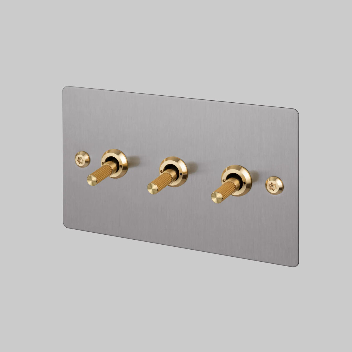 Buster and Punch three gang two way light switch in steel with brass linear knurled toggles