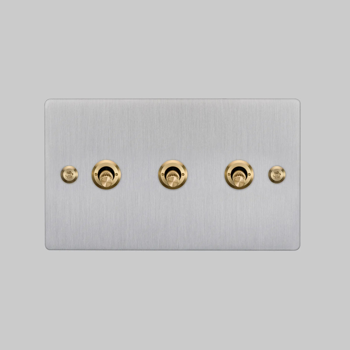 Buster and Punch three gang two way light switch in steel with brass linear knurled toggles