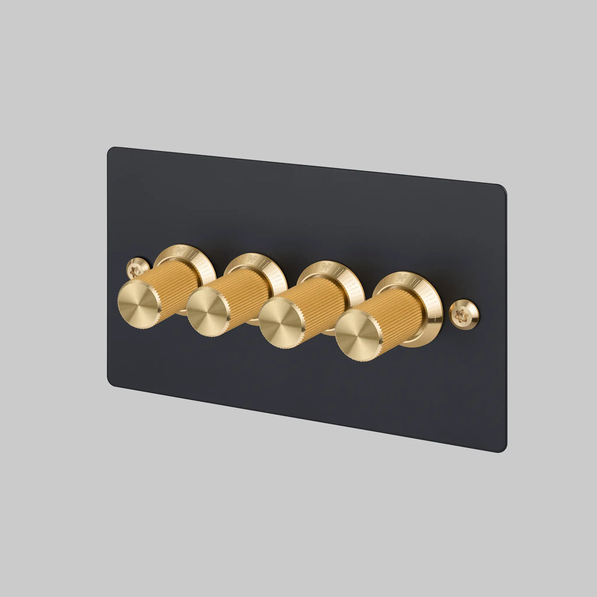 Buster and Punch four gang two way dimmer light switch with black plate and brass linear knurled knobs