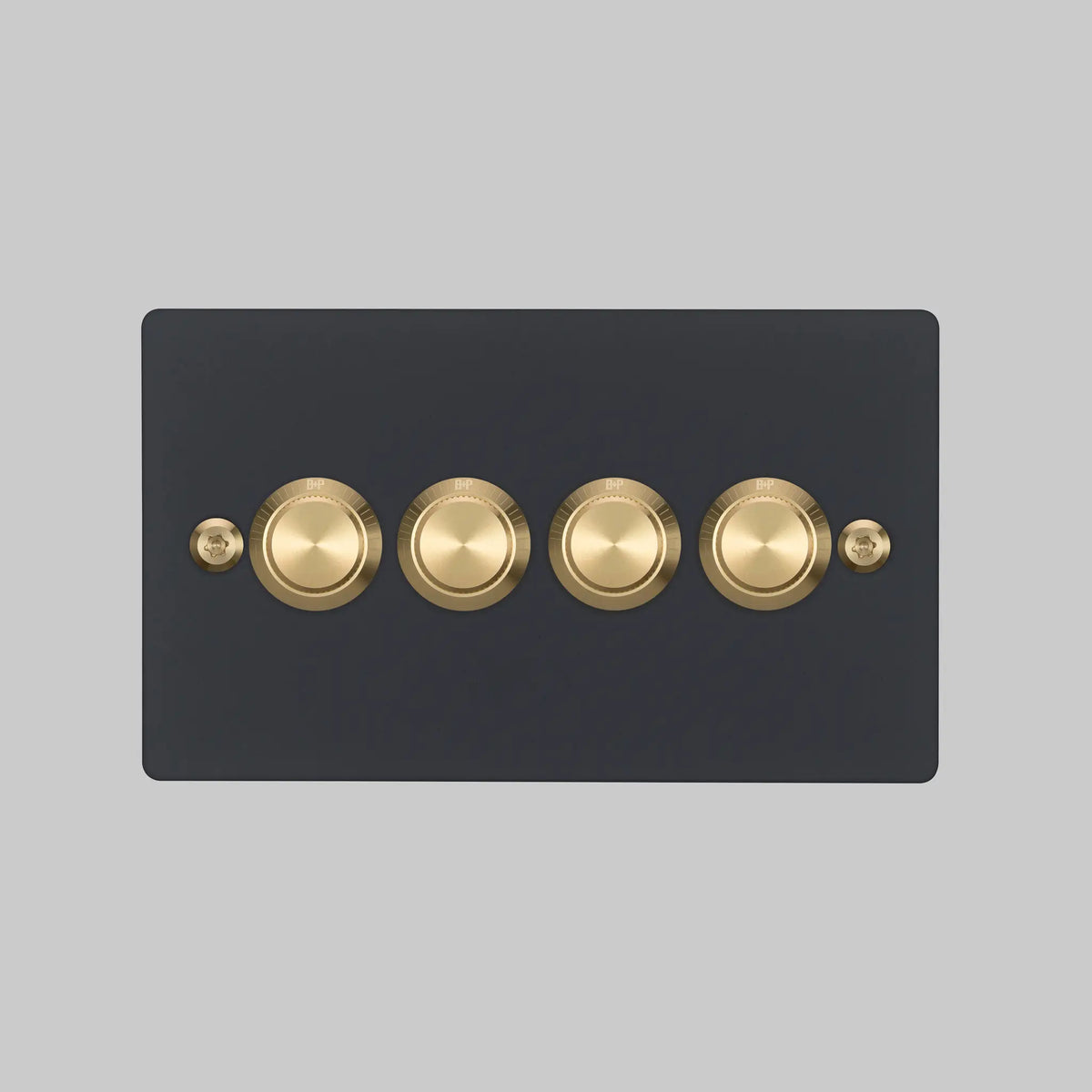 Buster and Punch four gang two way dimmer light switch in black with brass linear knurled knobs