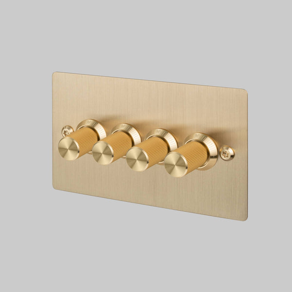 Four-gang dimmer switch in brushed brass with knurled knobs