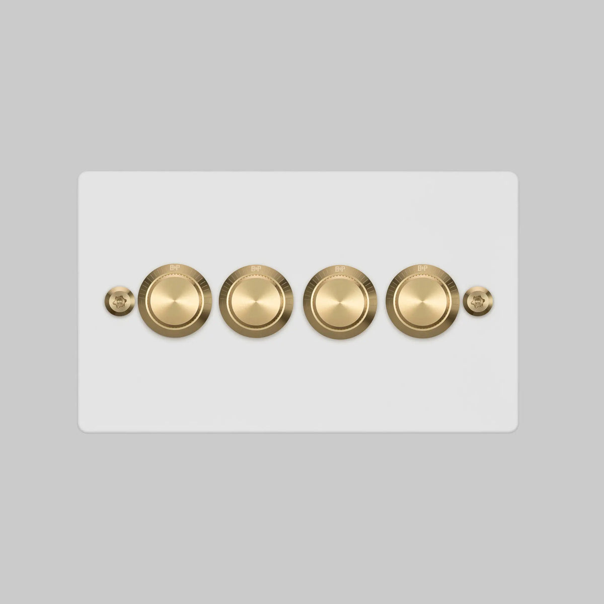 Buster and Punch four gang two way dimmer light switch in white with brass linear knurled knobs