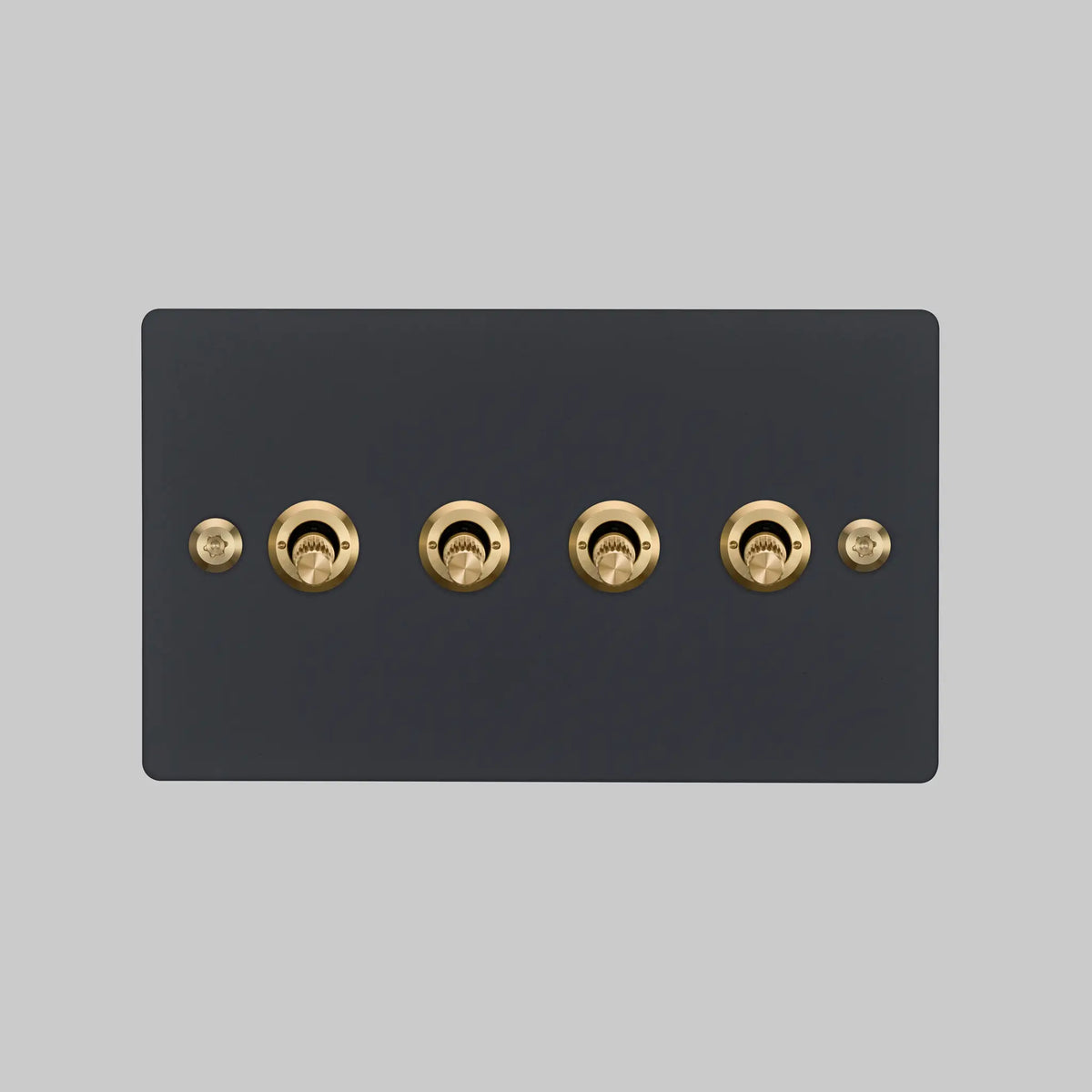Buster and Punch four gang two way light switch in black with brass linear knurled toggles