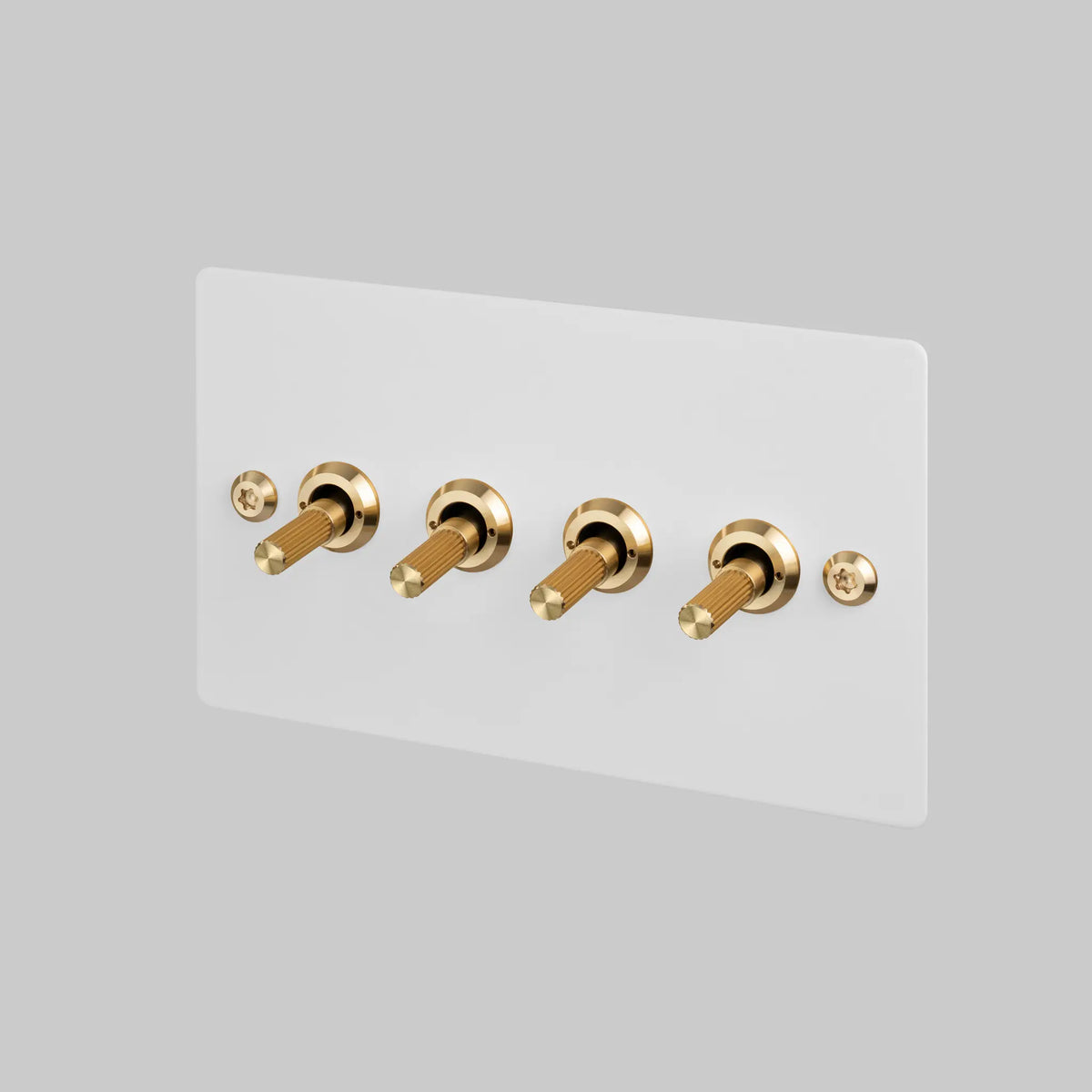 Buster and Punch four gang two way light switch with white plate and brass linear knurled toggles