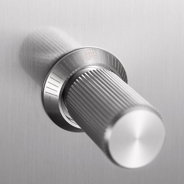 Close up of a brushed metal cylindrical knob with a textured grip and a logo