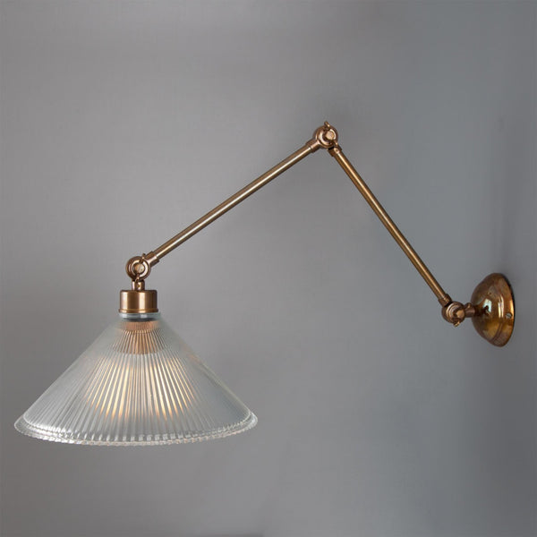 Mullan Rebell adjustable arm wall light in antique brass with a prismatic glass shade