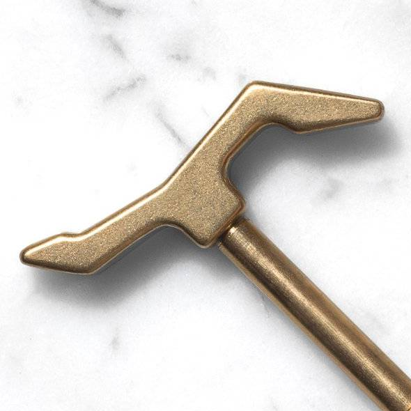 Close up of a brass key on a white marble surface