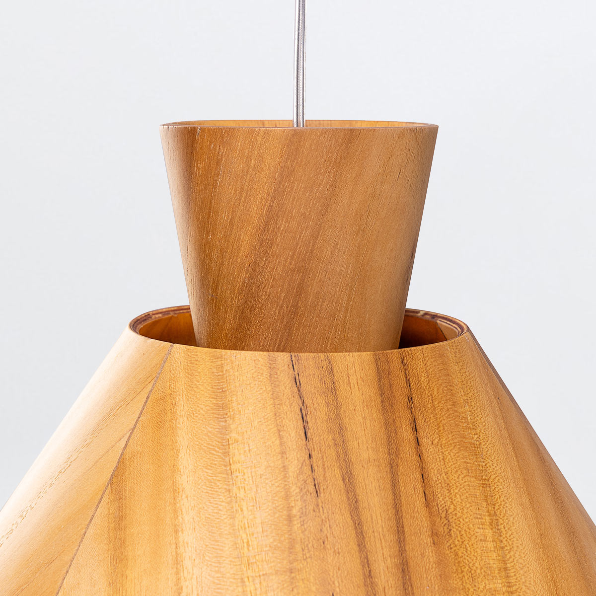 Close up of a wooden pendant light with a conical shade and cylindrical top