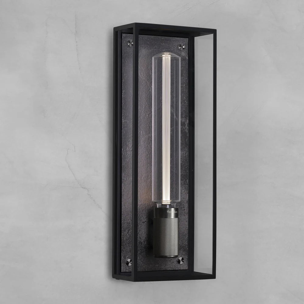 Black rectangular wall light with a clear glass tube and a textured metal base