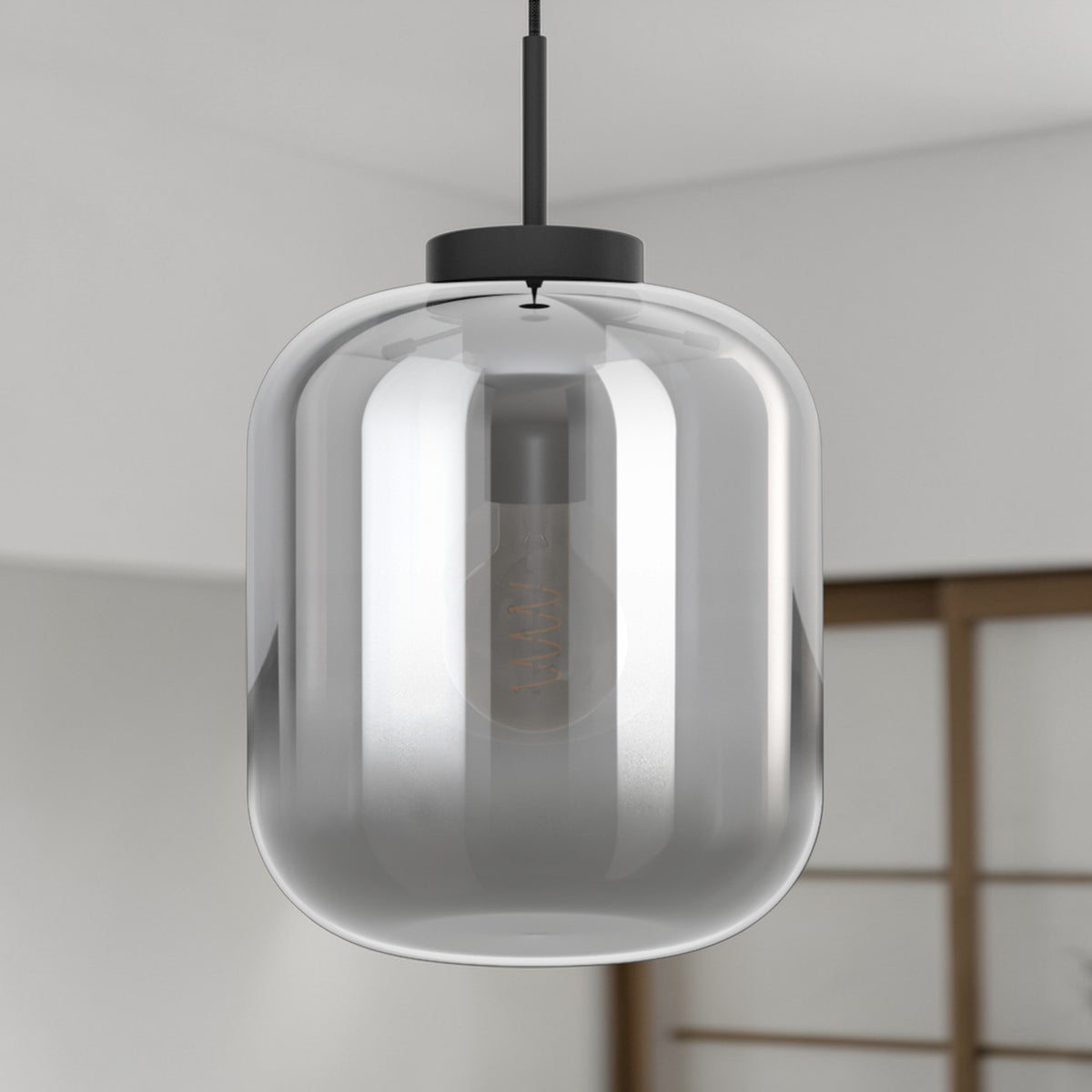 Modern pendant light with a clear, cylindrical glass shade and a visible filament bulb.